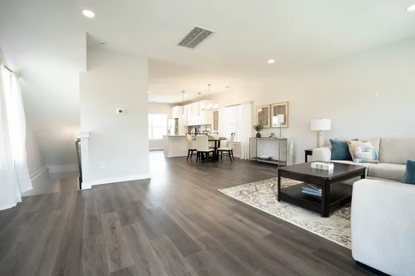 a living room with furniture and a wooden floor