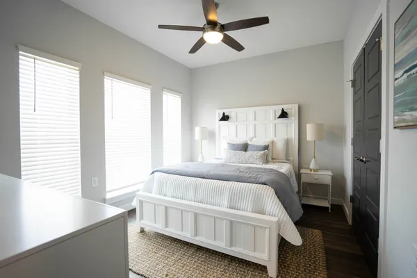 a room with a bed a chandelier and a window