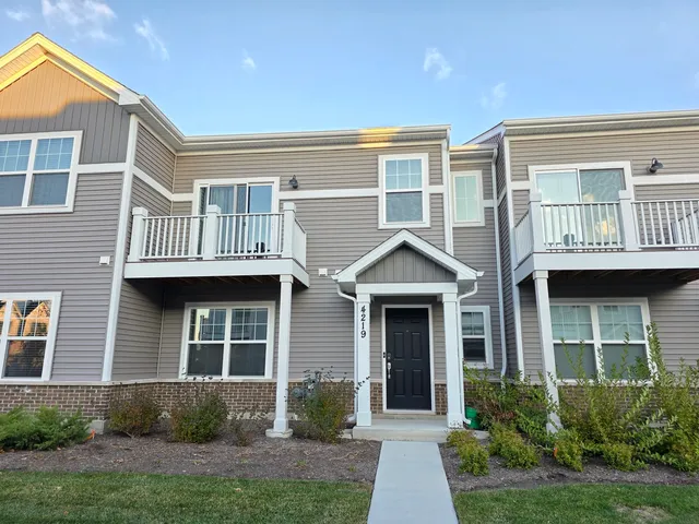 a view of a brick house with many windows and plants