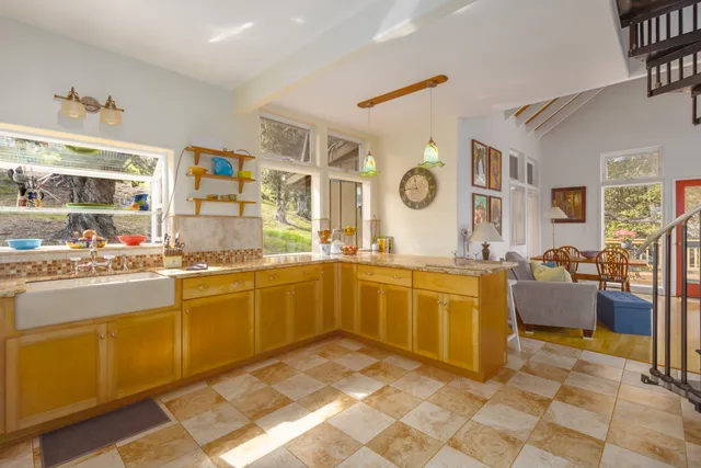 a large kitchen with granite countertop a sink and cabinets