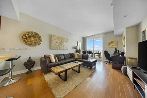 a living room with furniture a rug and a flat screen tv