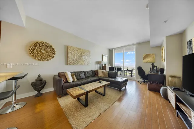 a living room with furniture a rug and a flat screen tv