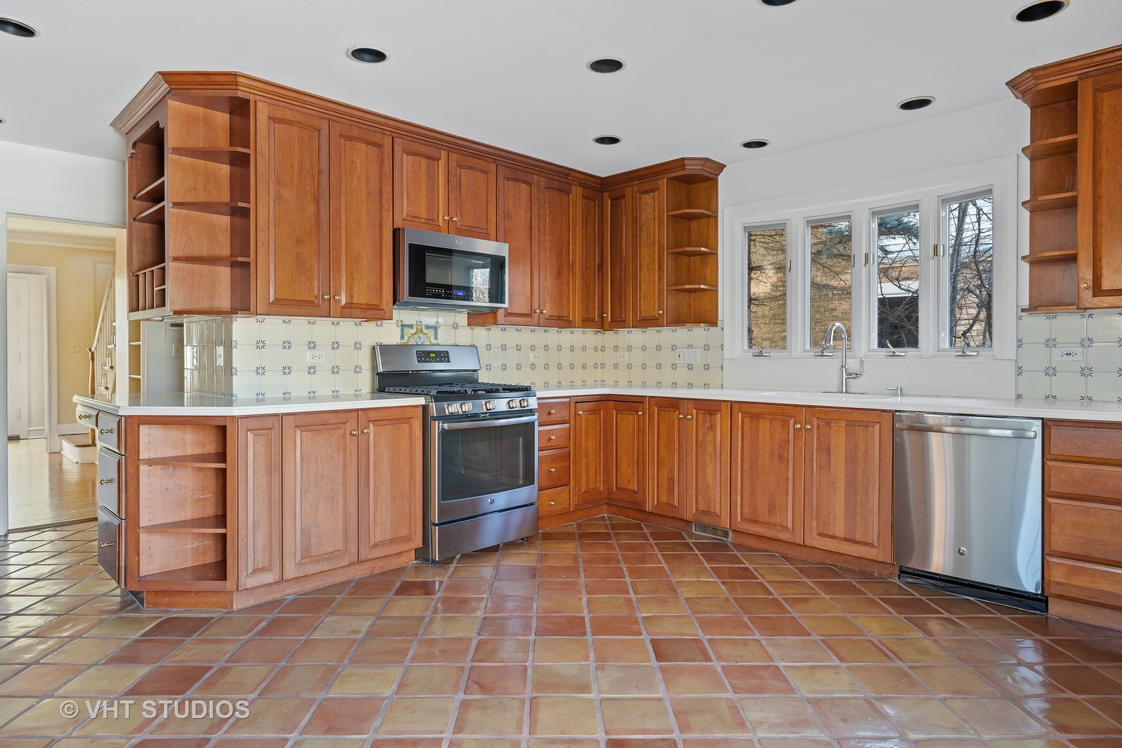 82 Warwick Road Winnetka, IL 60093 - Photo 8 of 23 a kitchen with stainless steel appliances granite countertop a stove a sink and a microwave