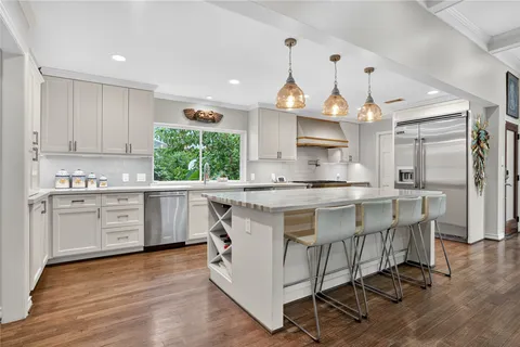 a kitchen with stainless steel appliances granite countertop a sink a stove and cabinets