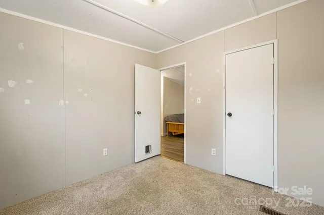 an empty room with closet and a hallway
