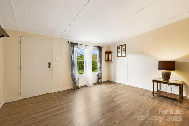 a view of a livingroom with wooden floor and a window