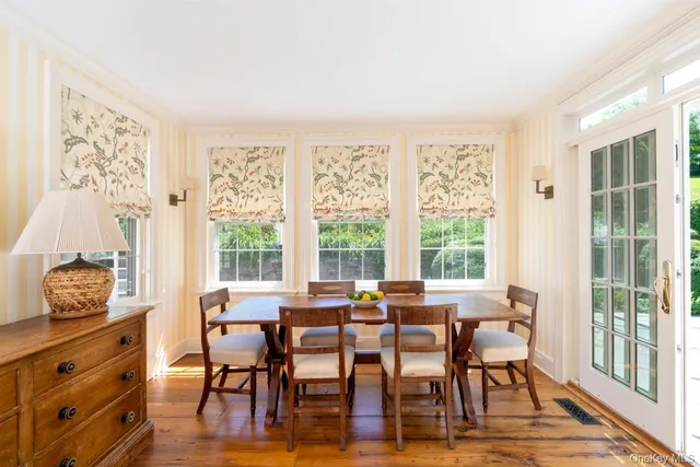 a view of a dining room with furniture large windows and wooden floor