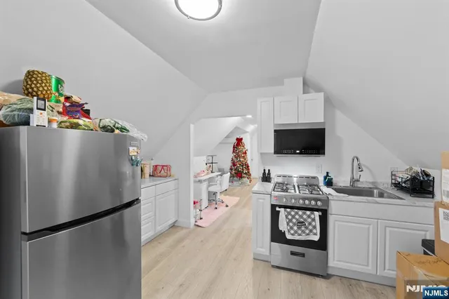 a kitchen with stainless steel appliances a refrigerator sink and cabinets