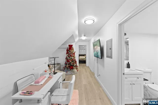 a view of a hallway with furniture and wooden floor