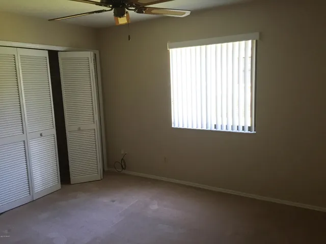 a view of empty room with wooden floor and floor to ceiling window