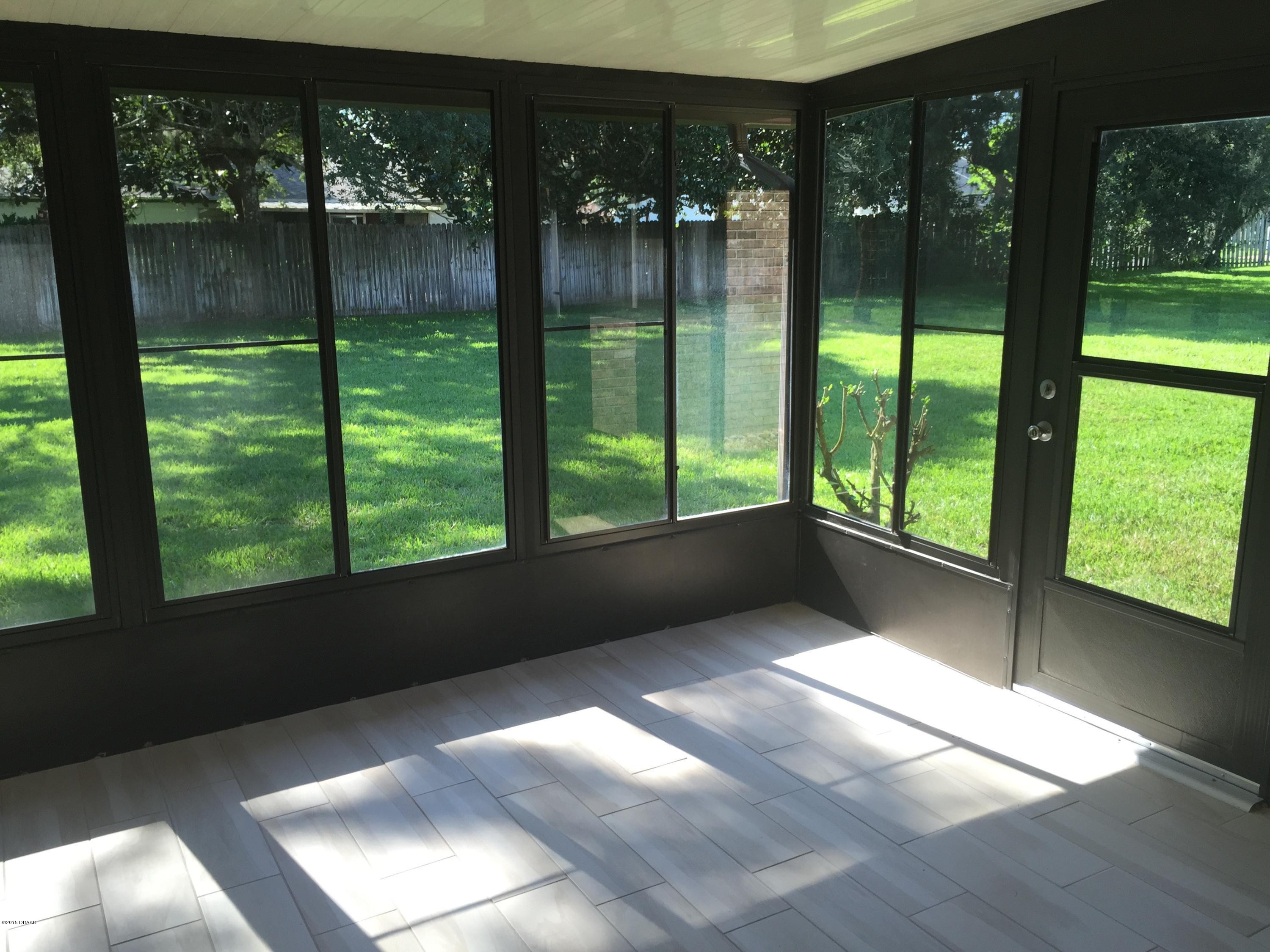 18 Mayfield Terrace Ormond Beach, FL 32174 - Photo 13 of 17 a view of empty room with wooden floor and floor to ceiling window