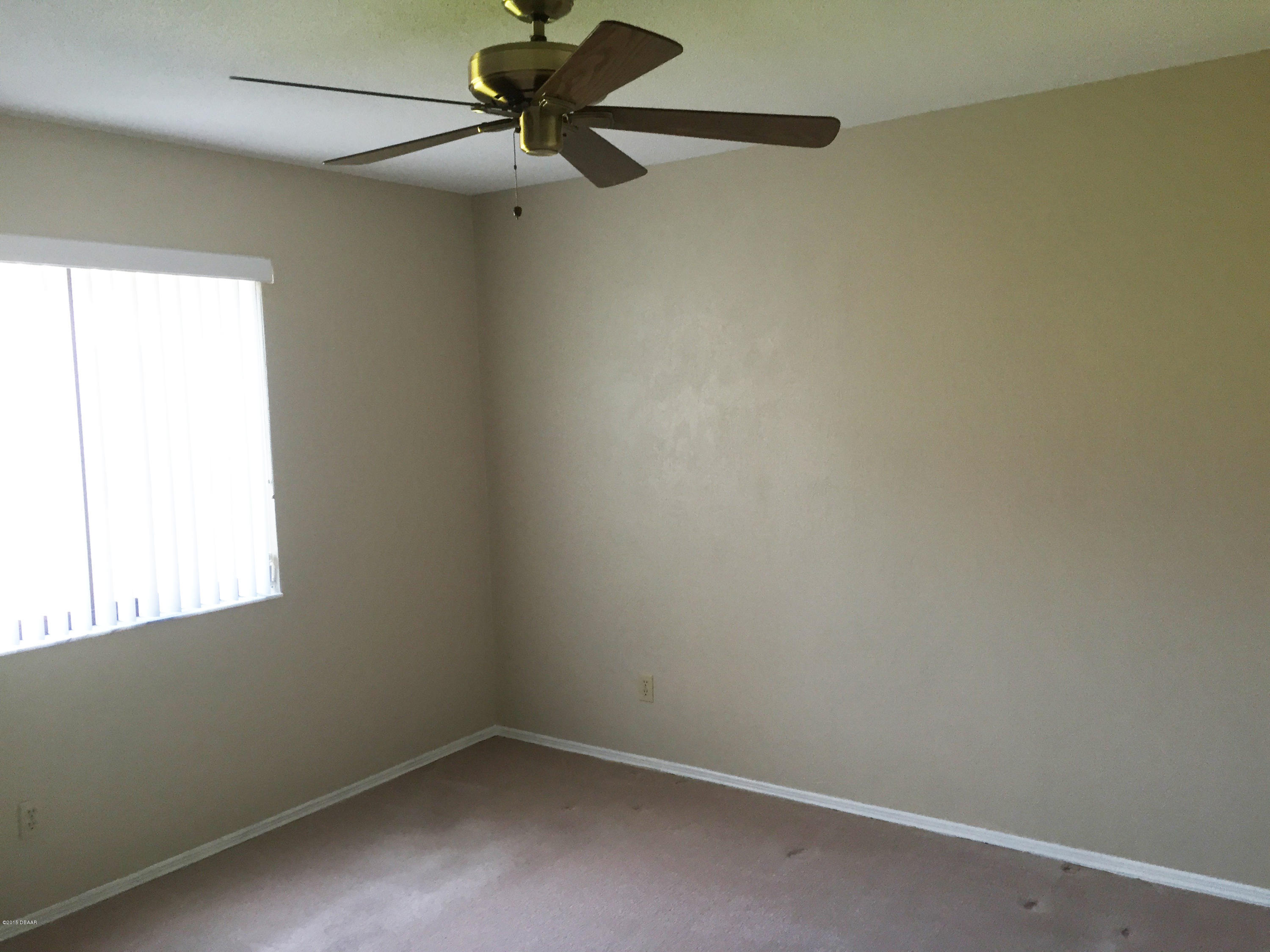 18 Mayfield Terrace Ormond Beach, FL 32174 - Photo 10 of 17 an empty room with a window and a fan