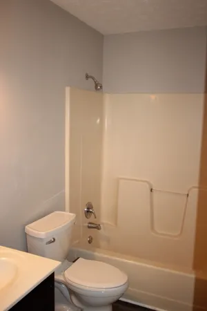 a white toilet sitting next to a bath tub