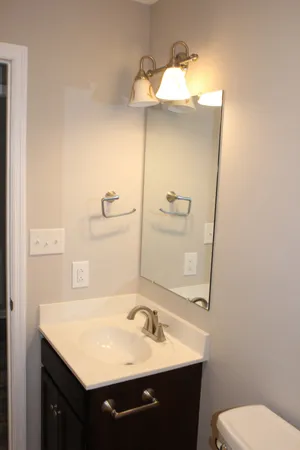 a bathroom with a sink vanity mirror and toilet