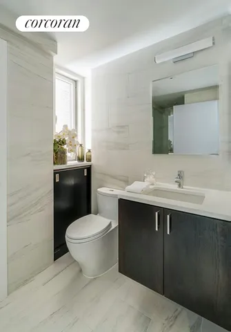 a bathroom with a sink toilet and mirror