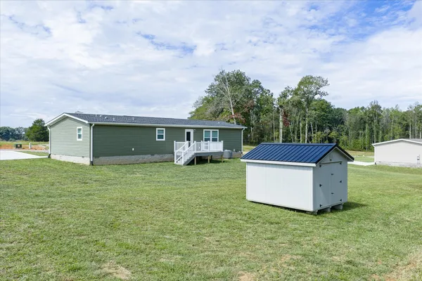 a front view of a house with a garden and trees