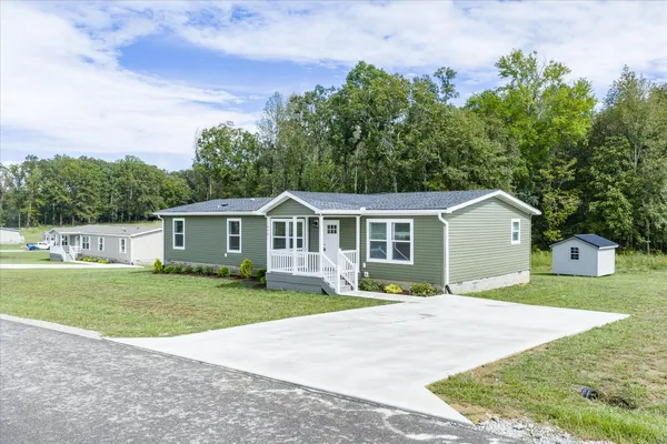 a front view of a house with a yard and trees