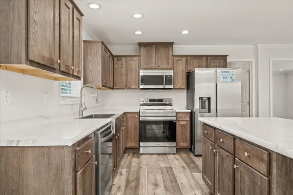 a kitchen with stainless steel appliances a stove a sink a refrigerator and cabinets