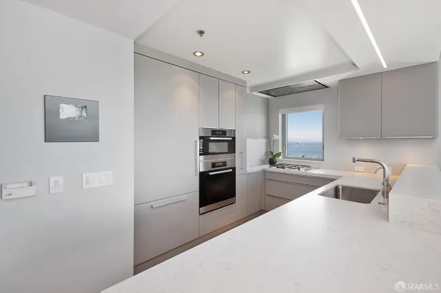 a kitchen with granite countertop a refrigerator stove and sink