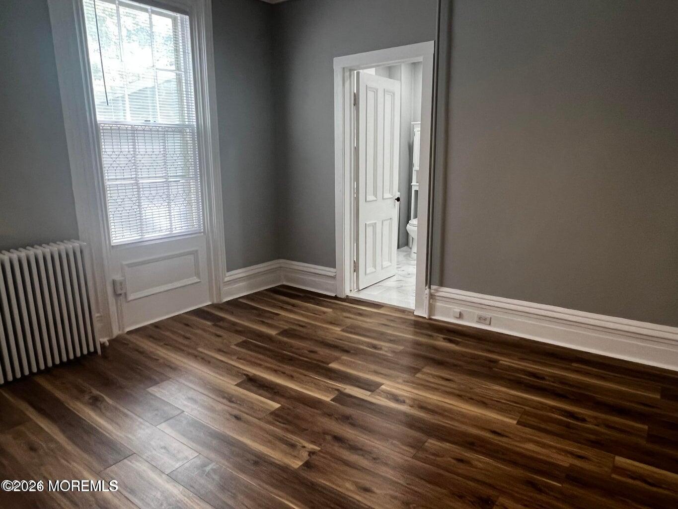 27 Spring Street Freehold, NJ 07728 - Photo 29 of 40 a view of an empty room with wooden floor and a window
