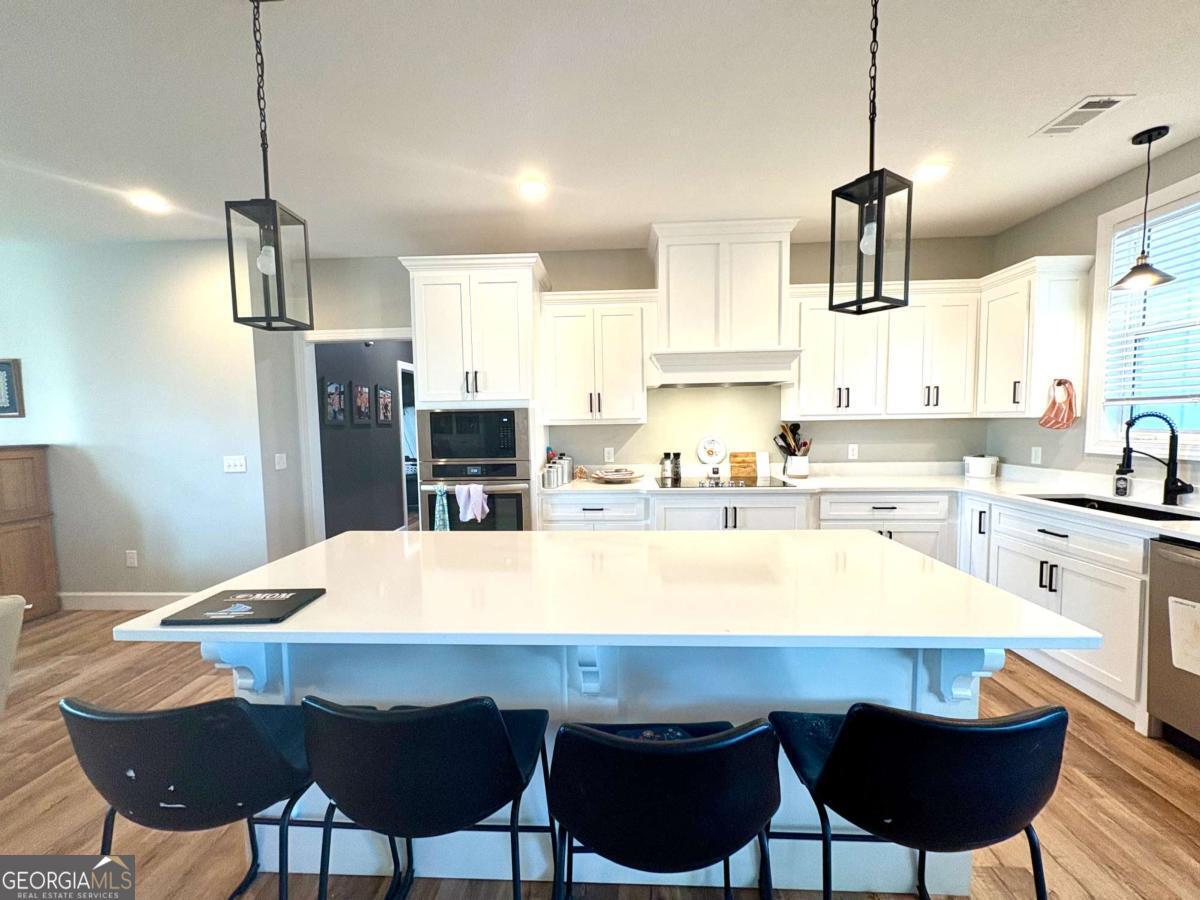 134 Austin Way Vidalia, GA 30474 - Photo 18 of 41 a kitchen with a dining table chairs sink and refrigerator