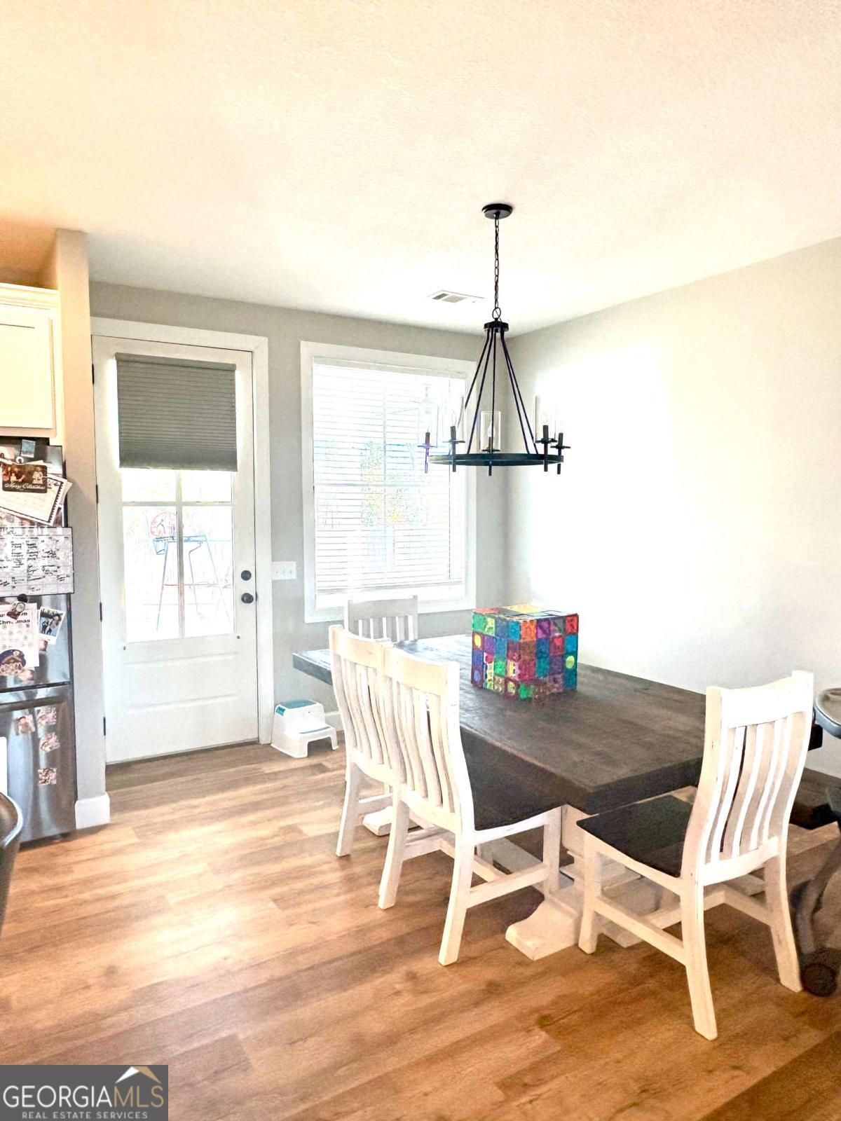 134 Austin Way Vidalia, GA 30474 - Photo 20 of 41 a dining room with wooden floor a chandelier a glass table and chairs