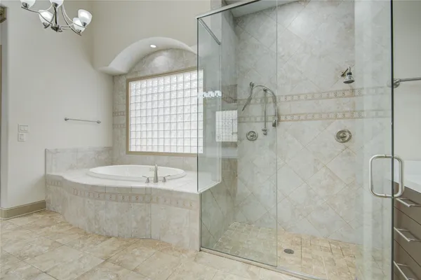 a bathroom with a granite countertop tub sink and mirror
