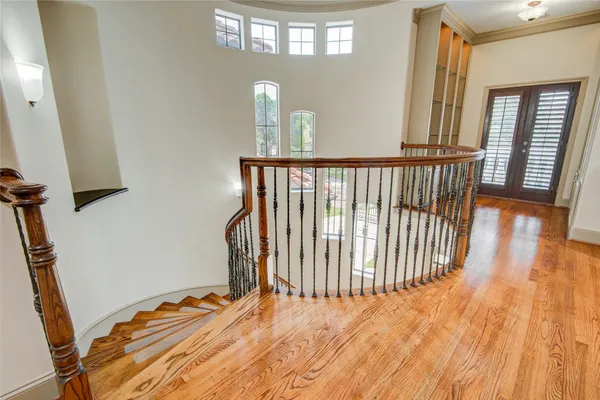 a view of a hallway with wooden floor and staircase