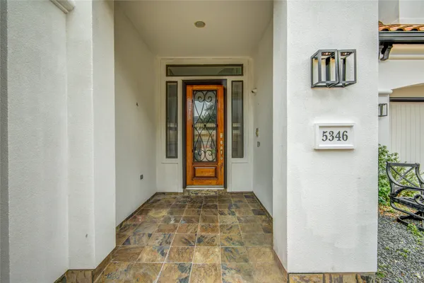 a view of a hallway with wooden floor and a bathroom