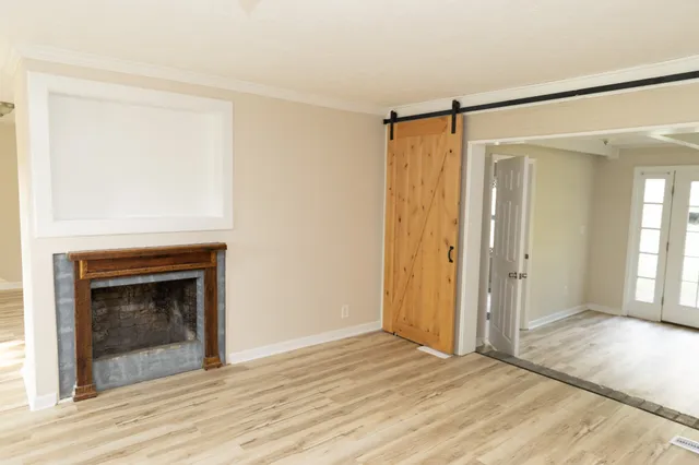 a view of empty room with wooden floor and fireplace