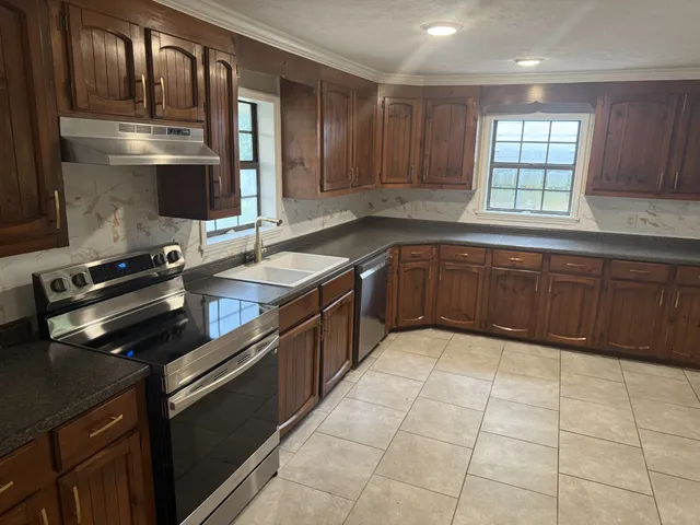 a kitchen with stainless steel appliances granite countertop a sink stove and cabinets
