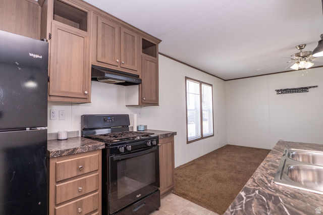 2491 Highway 89, Unit 403 Pleasant View, UT 84404 - Photo 14 of 32 Kitchen featuring wood-finish cabinetry, black appliances, patterned countertops, and a double basin sink