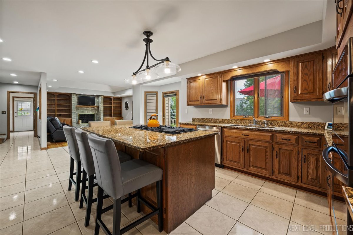 905 Merrill New Road Sugar Grove, IL 60554 - Photo 14 of 44 a open kitchen with stainless steel appliances granite countertop a stove top oven a sink dishwasher a dining table and chairs with wooden floor