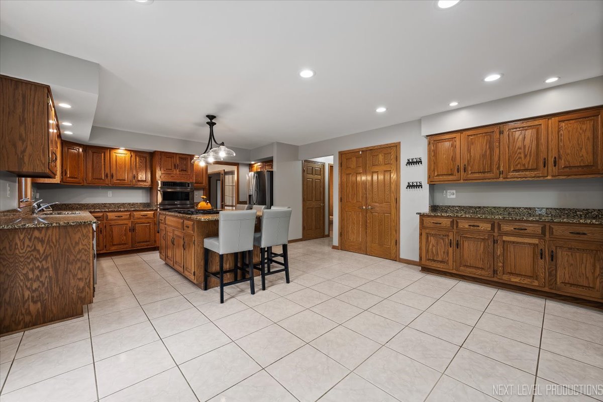 905 Merrill New Road Sugar Grove, IL 60554 - Photo 15 of 44 a kitchen with stainless steel appliances kitchen island granite countertop a sink and cabinets