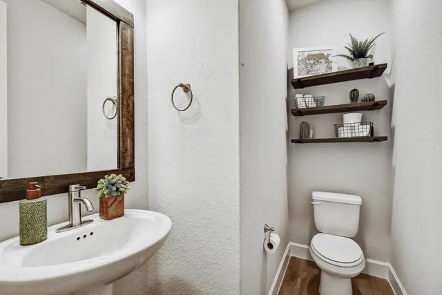 a bathroom with a toilet a sink and mirror