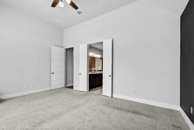 an empty room with closet and a chandelier fan