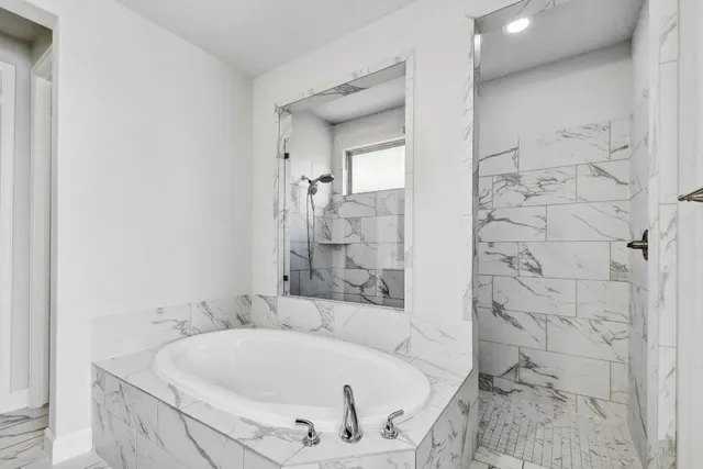 a bathroom with bathtub and shower