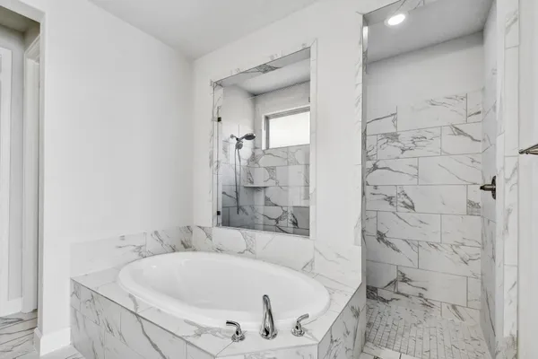 a bathroom with a double vanity sink a mirror and a bathtub