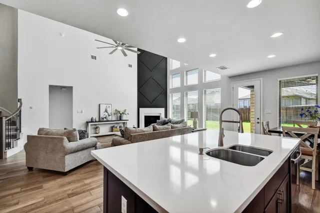 a kitchen with granite countertop a stove a sink a refrigerator and wooden cabinets