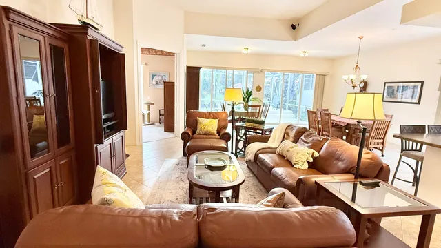 a living room with furniture a large window and a dining table