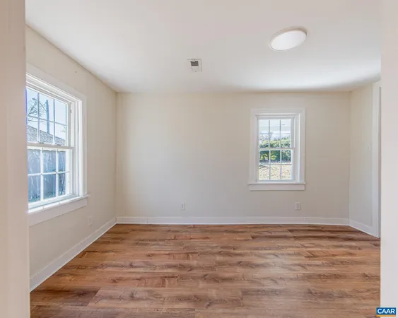 wooden floor in an empty room with a window