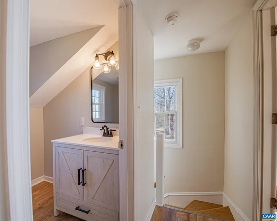 a bathroom with a sink vanity mirror and toilet