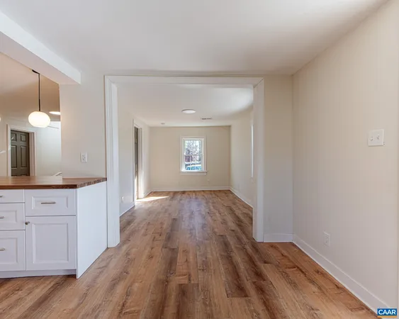 a view of a kitchen with wooden floor and electronic appliances