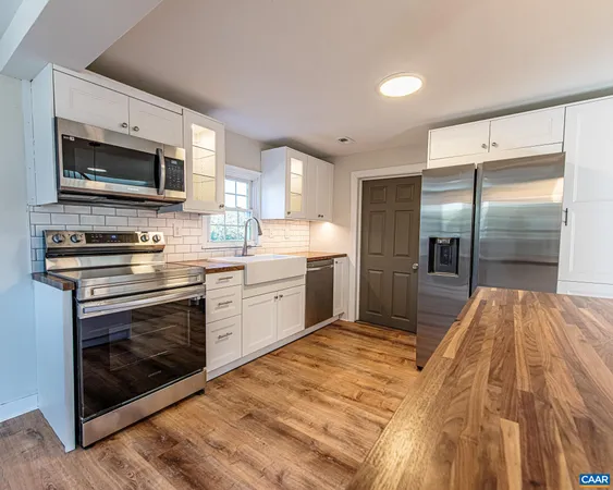 a kitchen with stainless steel appliances a stove a sink and a microwave