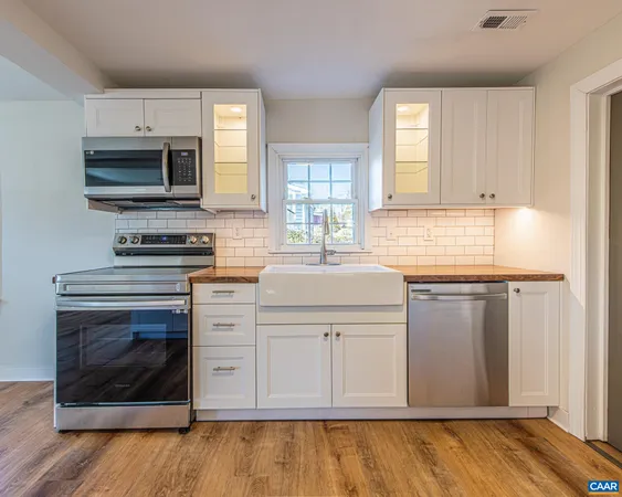 a kitchen with stainless steel appliances granite countertop a stove a microwave and a sink