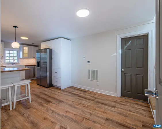 a view of a kitchen with wooden floor and chairs in a room