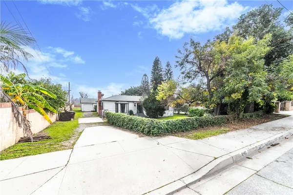 a front view of a house with a yard and potted plants