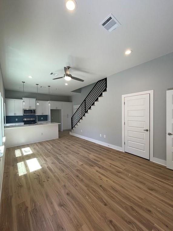 6014 Fairway Street, Unit 2 Austin, TX 78741 - Photo 3 of 20 Unfurnished living room featuring a ceiling fan, wood finished floors, stairway, and recessed lighting