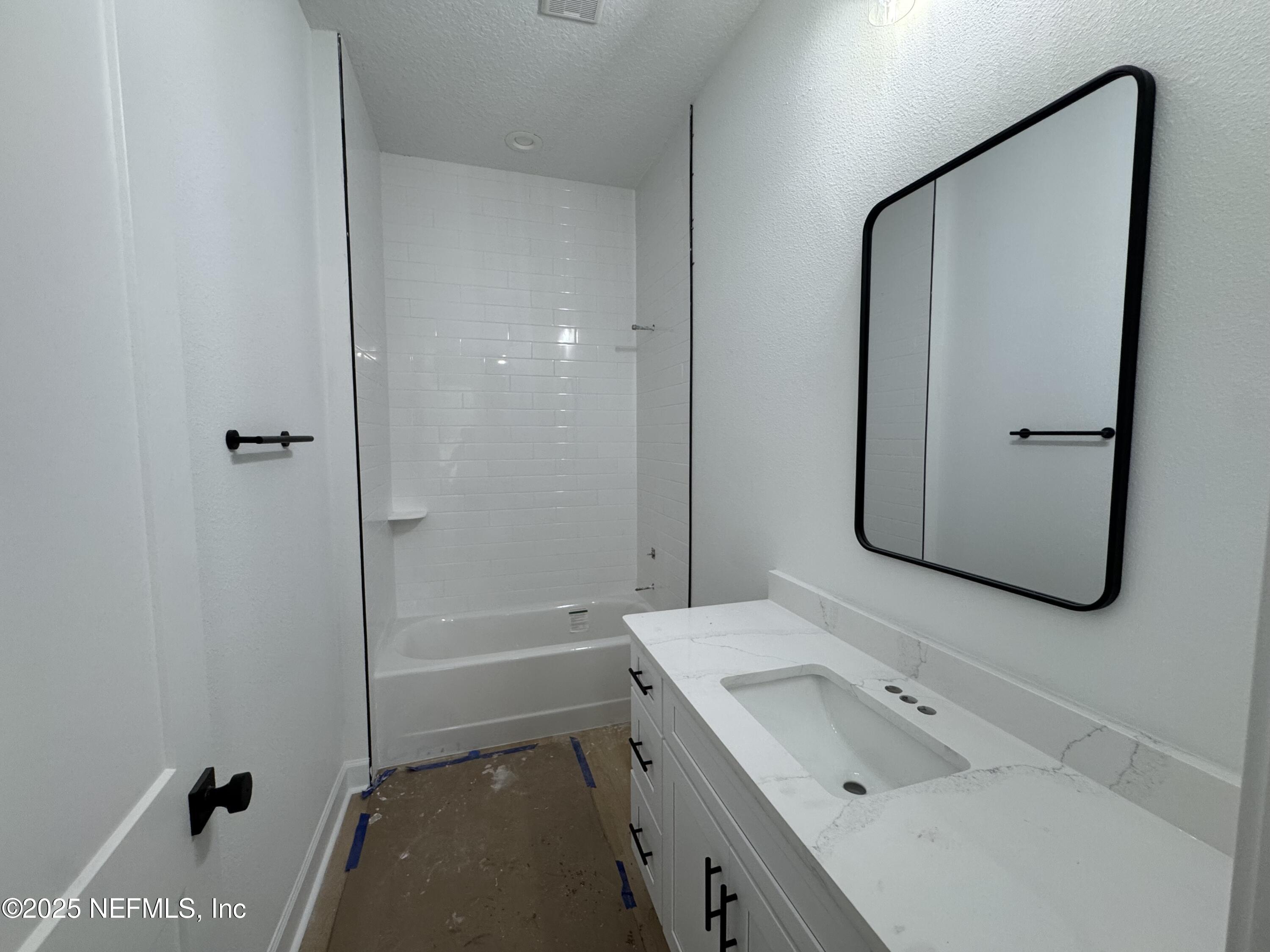 14167 Saddle Ridge Road Macclenny, FL 32063 - Photo 18 of 20 a bathroom with a tub sink vanity and mirror