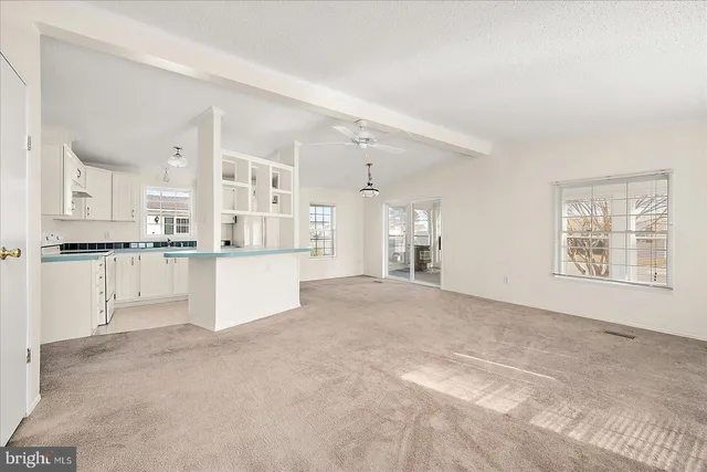 a view of a kitchen with refrigerator and window